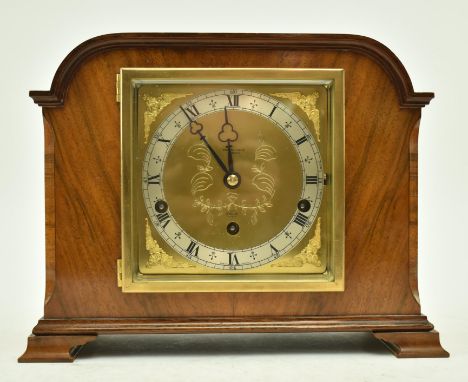 A mid 20th century walnut and gilt metal cased Elliott mantle clock. The clock with arched top, central gilt metal face with 