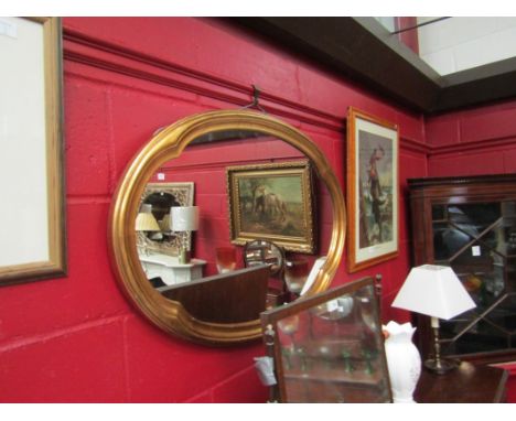 A gilt framed oval wall mirror with shaped frame, 60cm x 92cm overall