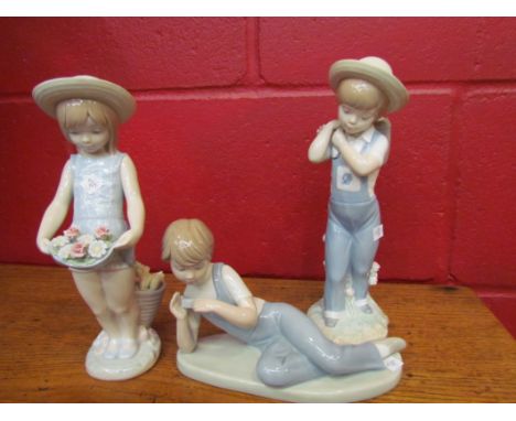 Two Lladro figures, boy and girl with flowers, boxed, No. 1-286 and 1-284, and a Nao figure, recumbent boy in dungarees  