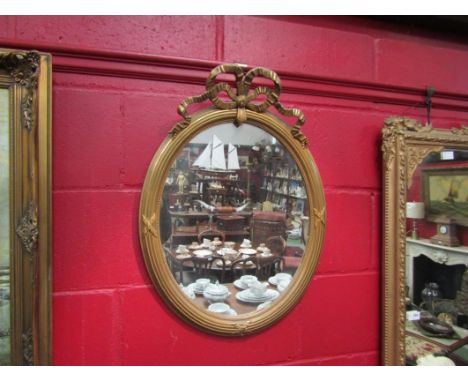 A 19th Century style gilt wall mirror, oval form with ribbon crest, 65cm x 48cm total