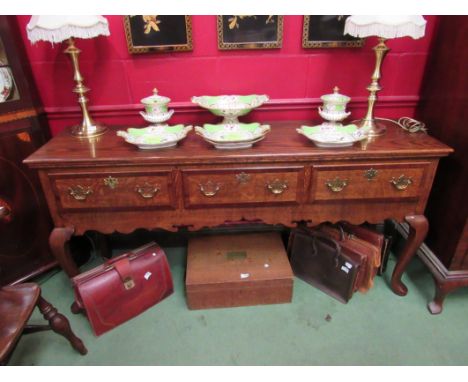 An 18th Century style North Country oak dresser base having mahogany crossbanding, the three drawers and shaped frieze on cab
