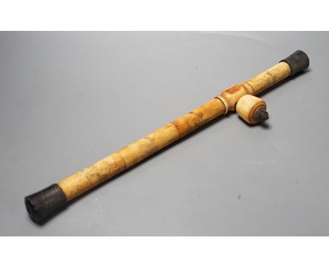 A Chinese bone opium pipe with figural decoration, 46cm wide