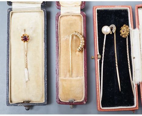 Three assorted early to mid 20th century yellow metal and gem set stick pins including diamond chip set horseshoe, 57mm and 1