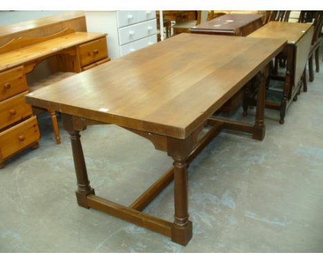 An Oak Gothic refectory table on ring turned cylindrical supports with plain cross stretchers.