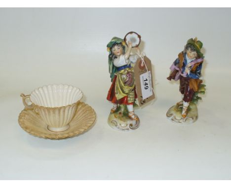 A Royal Worcester cabinet cup and saucer and two continental figurines " musicians " (3)