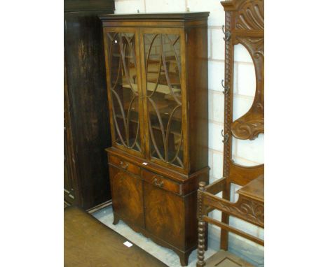 A Georgian style mahogany bookcase with a Greek key pattern cornice above a pair of astragal glazed doors, two frieze drawers