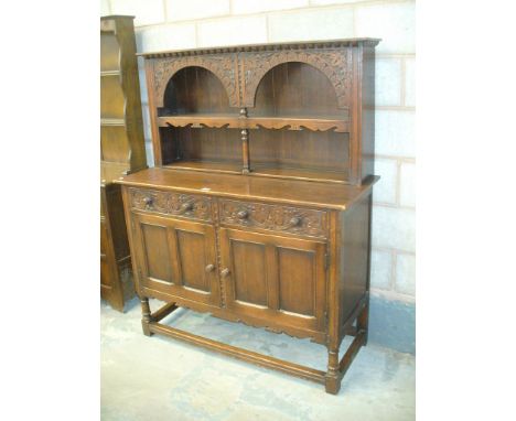 An Antique oak dresser , the high back with two arched apertures and ring turned uprights above a rectangular moulded top , t