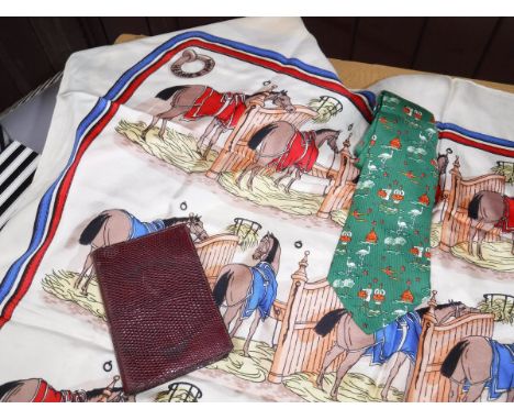 A Hermes silk tie depicting figures playing drums, storks and huts, a Hermes silk scarf depicting horses in stables and a Her