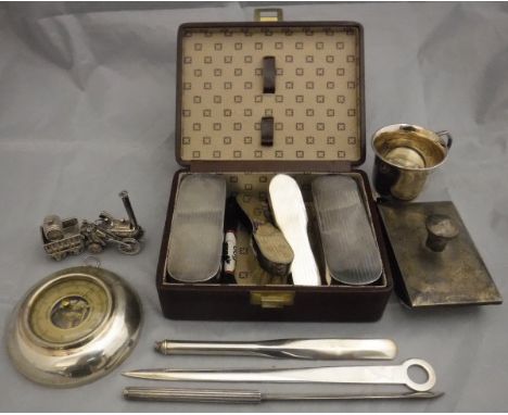 A collection of small silver wares to include a cased .800 silver backed four piece shoe brush set, a silver mounted aneroid 