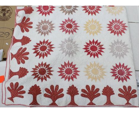 A 19th Century quilt with red stylised sunburst and floral motifs on a white ground with plain white back   CONDITION REPORTS