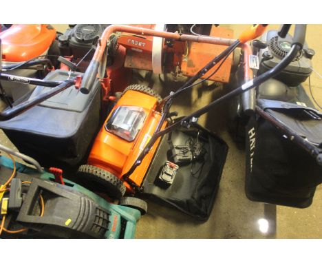 A Victor Tools cordless electric cylinder mower with battery and charger block