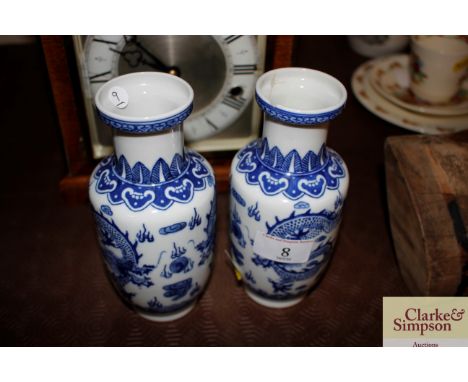 A pair of Chinese porcelain Rouleau shaped blue and white vases decorated with dragons, seal marks (one with repair)