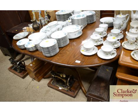 An Ercol extending dining table on central pillar base; and four matching stick back dining chairs with swan motif, three sta