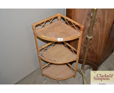 A three tier bamboo and wicker corner shelf