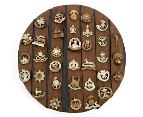 Collection of thirty four Victorian to First World War British cap badges mounted on a board, including Loyal Suffolk Hussar 