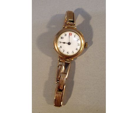A LADY'S VINTAGE 9ct GOLD WRISTWATCH WITH WHITE ENAMEL CIRCULAR DIAL, ARABIC NUMERALS AND A SWISS MOVEMENT ON A PERI STRAP
