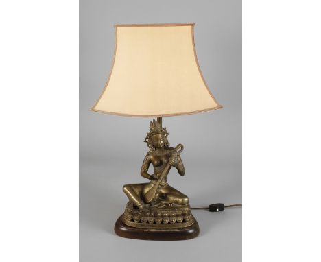 Figürliche Tischlampe20. Jh., ungemarkt, Bronze gegossen und bräunlich patiniert, geschwungener Holzsockel mit montierter Fig