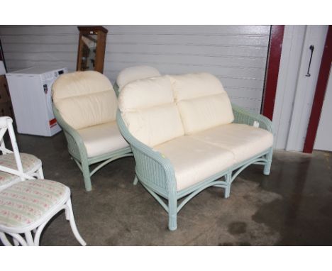 A green wicker conservatory sofa with cushions; and two matching armchairs 