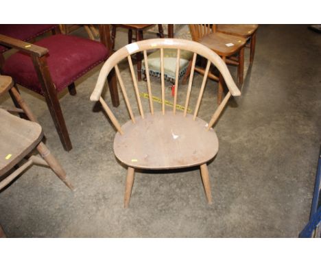 An Ercol style stick back, tub shaped low chair