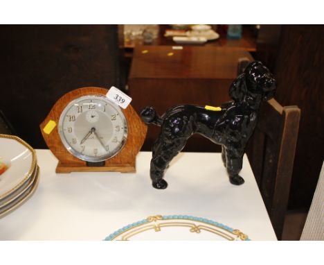 A Smiths alarm clock; and a china model of a poodle