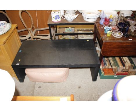 A modern designer style coffee table; and a leather pouffe