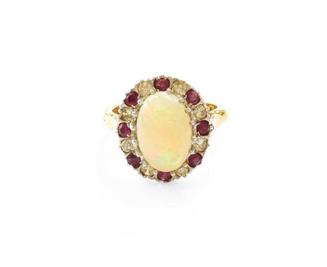 An 18 Carat Gold Opal, Diamond and Ruby Cluster Ring, the oval cabochon opal within a border of round brilliant cut diamonds 