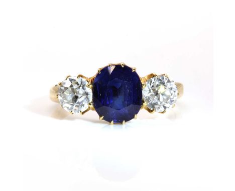 A gold sapphire and diamond three stone ring, c.1900, with an oval mixed cut sapphire claw set to the centre. An old European