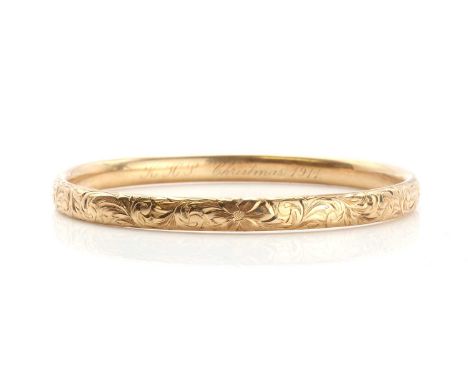 An American hollow slave bangle of elliptical form, with hand engraved scrolling decoration. A hand engraved presentation mes