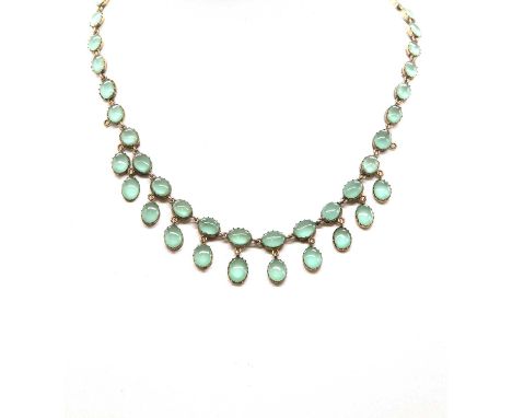 A Georgian gilt metal green paste fringed necklace,with a uniform row of oval green paste cabochons, suspending a fringe of o