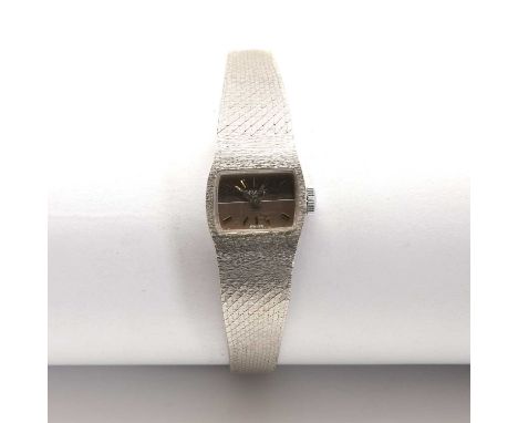 A ladies' 9ct white gold Orafe mechanical bracelet watch, c.1970,with a tonneau case, 15.10mm wide. A two tone smoke coloured