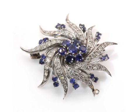 A sapphire and diamond Catherine wheel style brooch/pendant,with a central cluster of circular mixed cut sapphires, all claw 