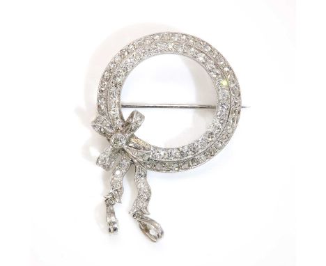 An Art Deco diamond set circle and bow brooch, c.1925,with a central hoop of eight cut diamonds, to an outer hoop of rose cut