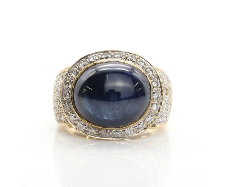 A gold sapphire cabochon and diamond ring, set to the centre with a horizontal oval cabochon sapphire measuring 12.80 x 10.90