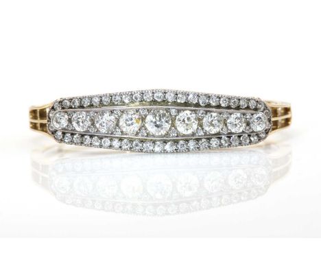 A Continental style diamond set hinged bangle, c.1890,with a diamond set central pavel. A row of nine graduated old European 