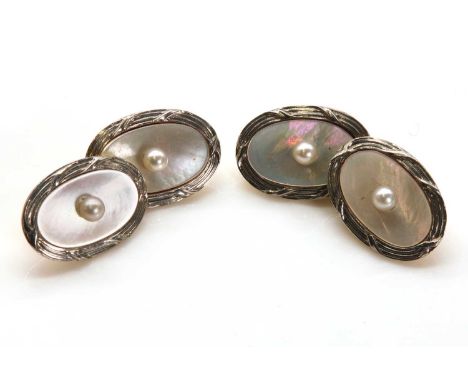 A pair of Art Deco oval chain link cufflinks, with a seed pearl peg set to an oval mother of pearl plaque. White reeded borde