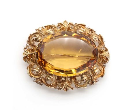 A single stone citrine brooch, c.1830-1840,with an oval Lisbon cut citrine, claw set to a frame of repousse scrolls and canne