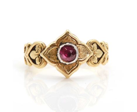 An 18ct gold garnet memorial ring,with a circular mixed cut garnet in silver clawed collets, to gold quatrefoil head, scrolli