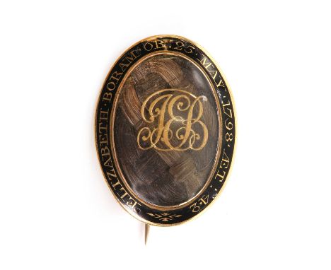 A Georgian gold oval memorial brooch,with a central woven hair panel, overlaid with a monogram, with a glass cover. A black c