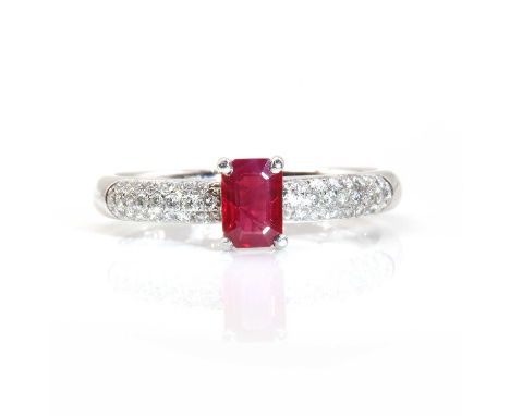 A platinum single stone ruby ring with pavé set diamond shoulders, by Disdale and Ellis c.2006,an emerald cut ruby, four claw