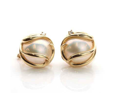 A pair of Continental cultured mabé pearl and diamond clip earrings,with a 14mm cultured pearl enclosed in a sweeping frame. 