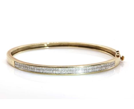 A 9ct gold diamond set hinged bangle,with two rows of princess cut diamonds, invisibly set to a flat section top half. A tape