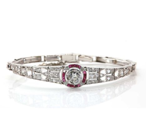 A French Art Deco diamond and ruby target style bracelet, c.1925, with an old European cut diamond claw set to the centre. A 