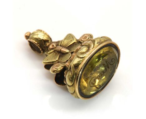 A two colour gold seal fob,with oval citrine intaglio engraved with 'Mary', to floral and butterfly motif mount. Tested as 14