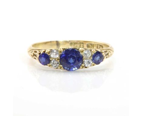 A sapphire and diamond carved head ring, c.1900,with three graduated circular mixed cut sapphires, claw set with pairs of dia