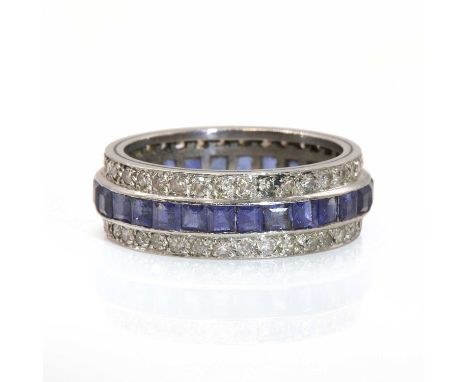 A three row sapphire and diamond full eternity ring,with a central row of calibre cut sapphires, all channel set. A row of ei