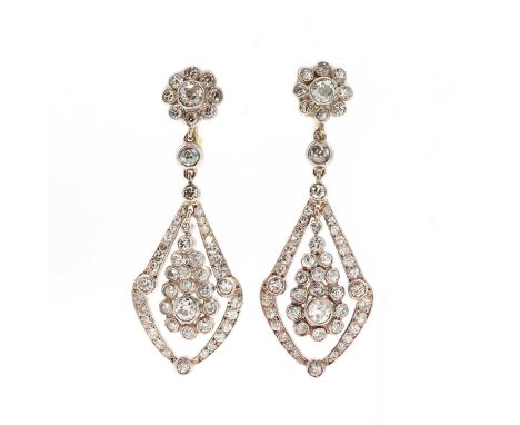 A pair of diamond cluster drop earrings,with a kite shaped diamond set frame below. The daisy cluster top composed of an old 