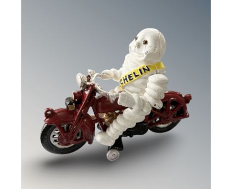 A cast iron Michelin man on motorbike figure, height 16 cm.