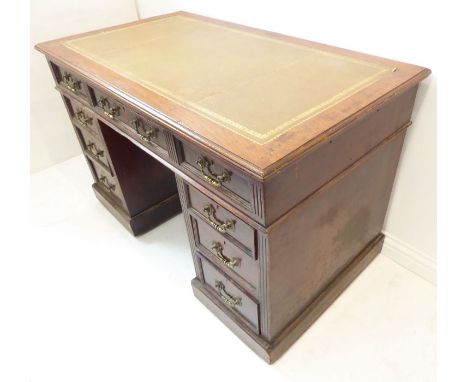 A late 19th / early 20th century walnut pedestal desk in Georgian-style. The light-green gilt-tooled leather inset moulded to