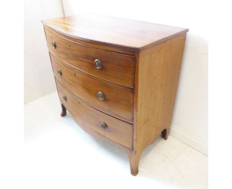 An early 19th century bow-fronted mahogany chest; the reeded edge top above three full-width graduated drawers, shaped apron 