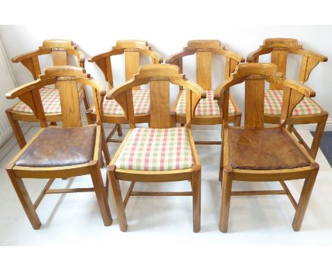 A good set of seven Art Deco period/style light oak dining chairs; the central vertical rectangular splat headed with foliate